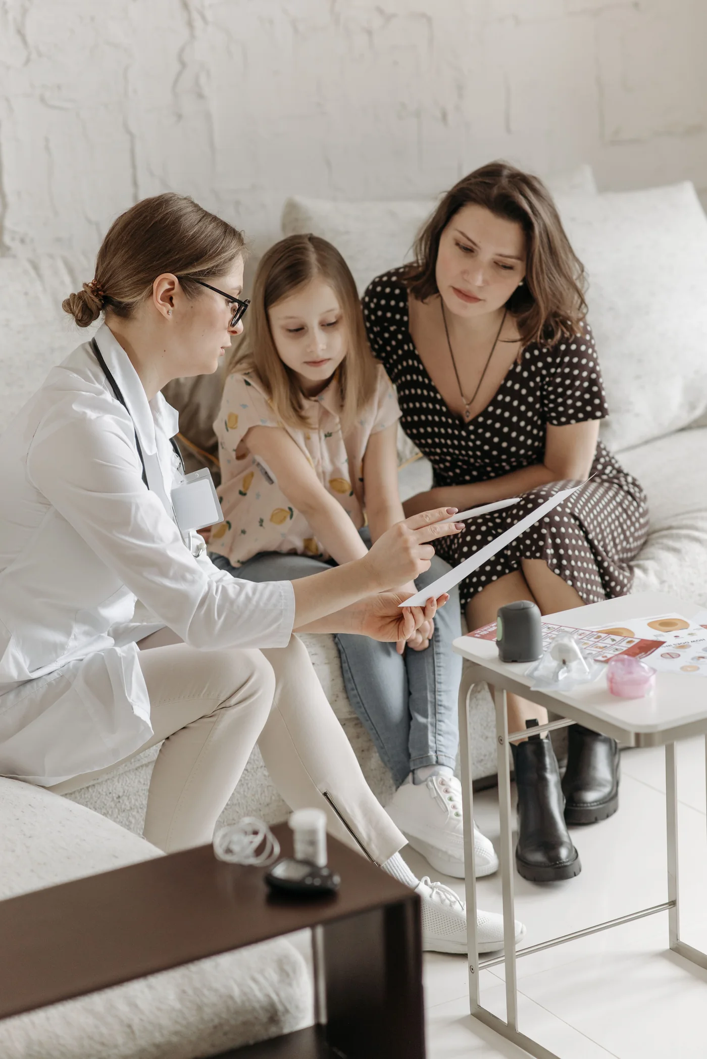 Profissional de saúde conversando com mãe e criança durante atendimento